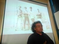 El académico  durante una conferencia en jornadas de Postgrado de la U. de Chile. Al fondo una imagen de la banda "Los Pinochet Boys"