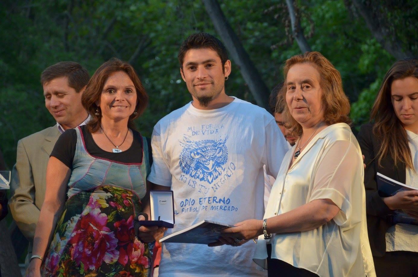 Mariana Morgado y Decana Marcela Pizzi entregando premio Espíritu Deporte Azul al estudiante Camilo Núñez