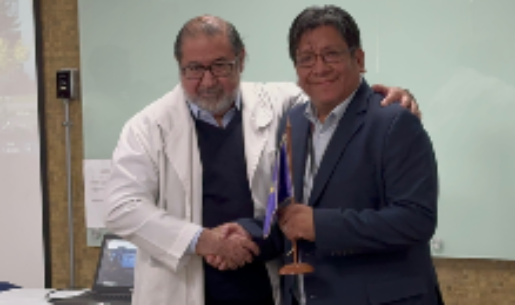 El doctor Luis Risco hace entrega del banderín institucional de la Clínica Psiquiátrica Universitaria al doctor Pablo Gaspar