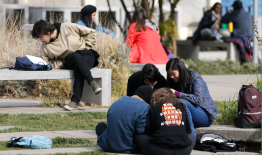 Estudiantes en el patio del Campus Juan Gómez Millas, sentados, estudiando, conversando