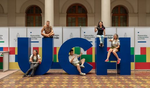 Letras gigantes UCH, con estudiantes posando en ellas, al interior de Casa Central