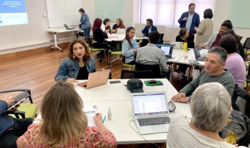Taller en torno al Proyecto de Formación Ciudadana del CUECH: Académicas/os, funcionarias/os y estudiantes, dialogando, distribuidos en mesas de trabajo en la sala 240 de Casa Central de la U. de Chile