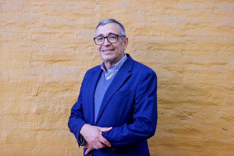 Medio plano del profesor Abdeljalil Akkari, podando a la cámara sonriente