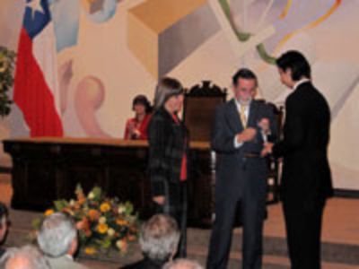 La Prof. Patricia Vargas en el momento de la entrega de su medalla y diploma en manos del Rector Pérez.