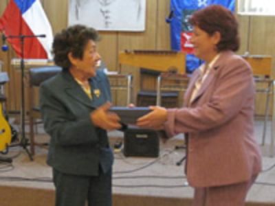 La Prof. Dina Alarcón (izquierda) recibió de manera simbólica el reconocimiento para Mercedes Acevedo, quien no pudo estar presente.