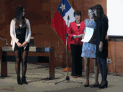 La profesora María Isabel Salina entrega titulo a una alumna. Al costado, Betty Gutiérrez, Secretaria de Pregrado