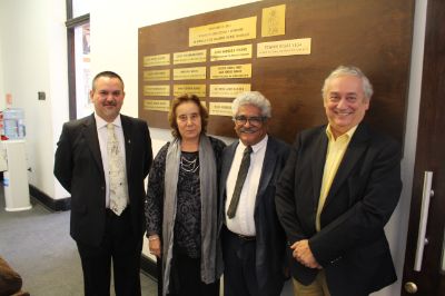 Autoridades de la FAU y Edward Rojas junto a la placa que recuerda a los premios nacionales egresados de la Facultad.