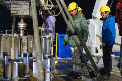 La investigadora postdoctoral del DGF, Lucía Villar (de parka verde y casco amarillo), a bordo del buque Falkor (too), del Instituto Schmidt Ocean, durante una expedición en costas chilenas.