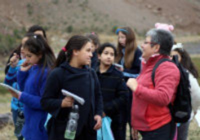 Laura Gallardo, directora del (CR)2 y académica FCFM de la Universidad de Chile apoyando a las niñas en su exploración. 