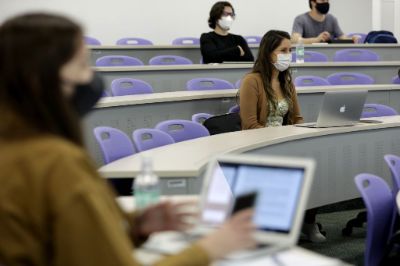 Estudiantes en una sala de clases con mascarilla y utilizando notebooks