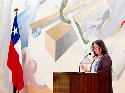 Leonor Armanet, directora del Departamento de Pregrado de la U. de Chile, hablando en la testera del Salón de Honor de Casa Central.