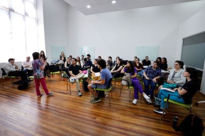 Docentes del programa de inducción a la docencia de pregrado, sentados en grupo, escuchando a la profesora que habla adelante, en la sala 40 de casa central