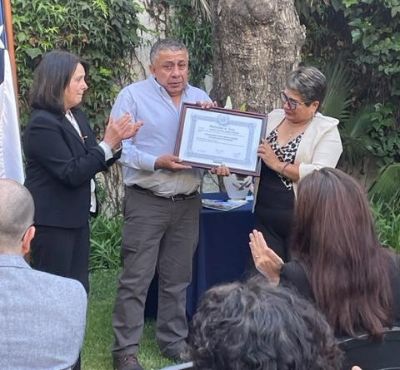 La Directora de Pregrado de la Universidad, prof. Leonor Armanet, entrega el título póstumo de Internacionalista a los padres de Consuelo.