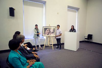 La directora de la Dirección de Bienestar y Desarrollo Estudiantil, Pamela Díaz-Romero, hizo entrega de un cuadro de Amanda Labarca para la residencia al estudiante Ignacio Escobar.
