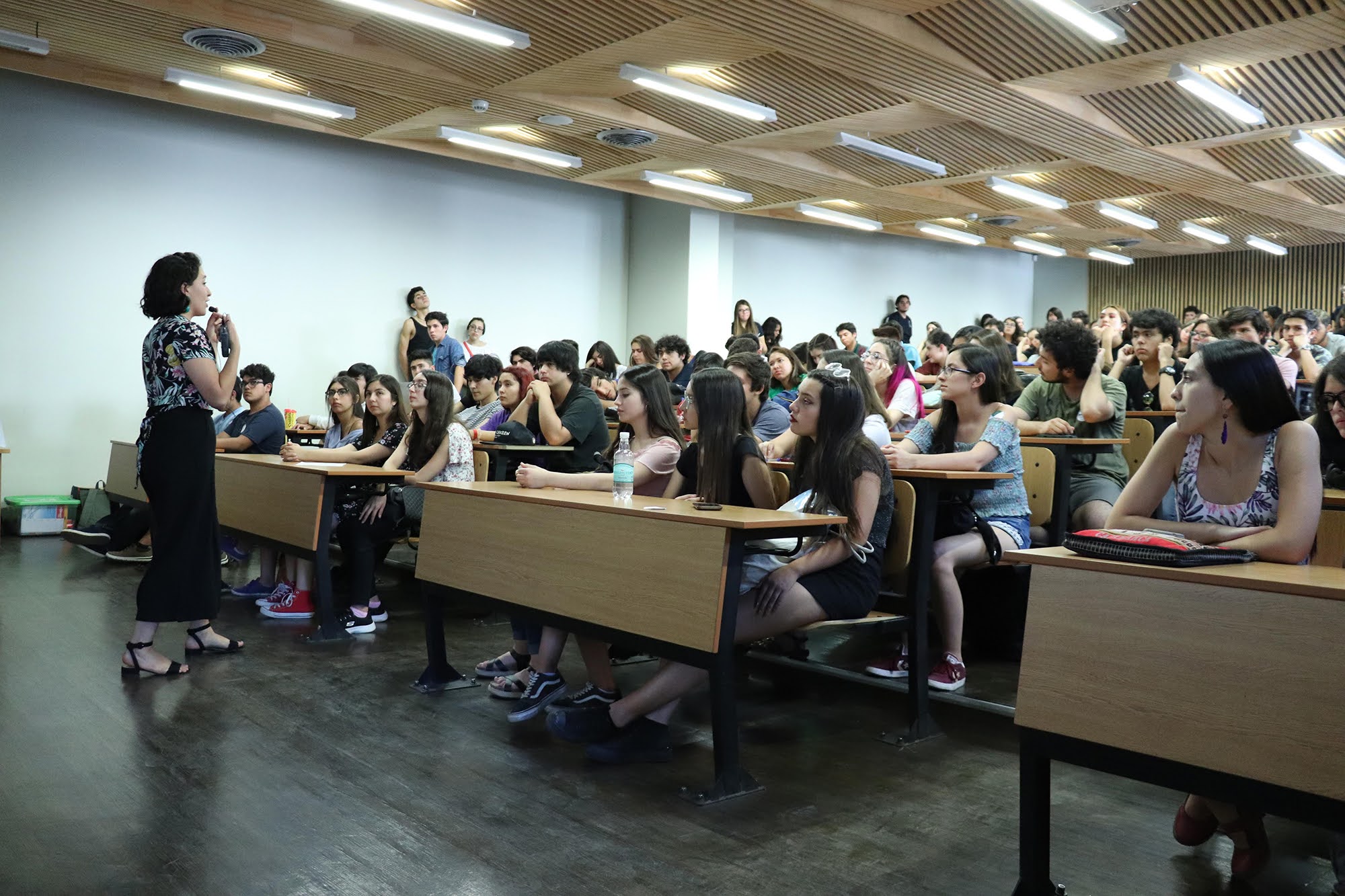 En la foto, grupo de estudiantes tomando atención, en un auditorium